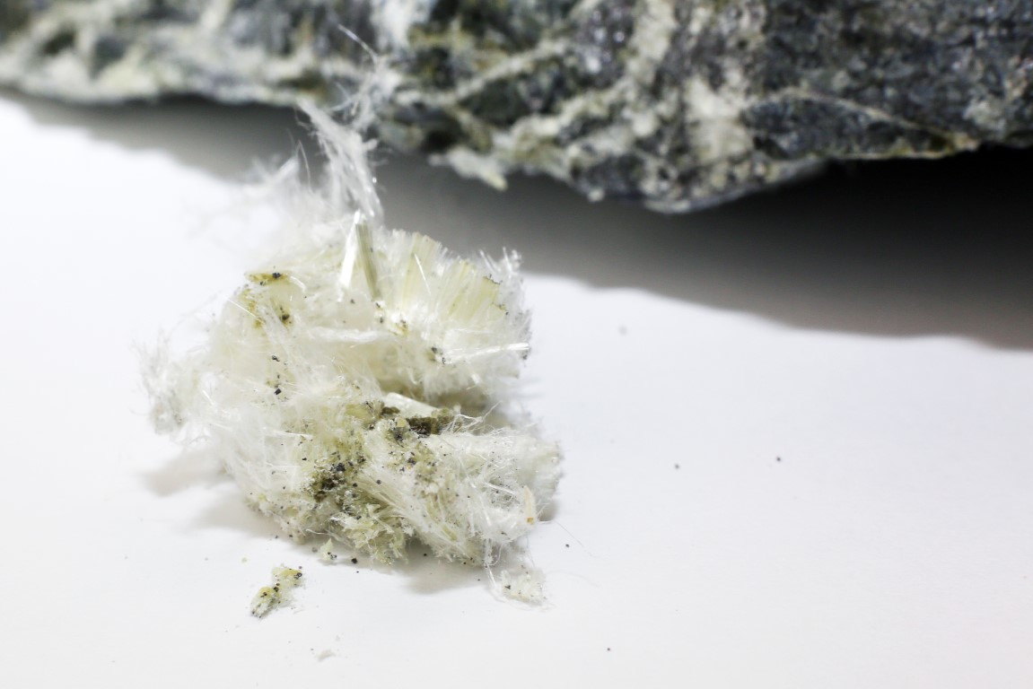Chrysotile asbestos fibers lie in a heap on a white background. Macro photography